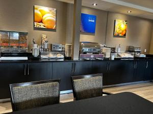 a coffee shop with a counter with two chairs at Comfort Inn in Saint-Georges