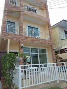 a house with a white fence and a balcony at Bann Lom Le Guest House in Hua Hin