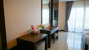a hotel room with a desk and a bed at VISA Hotel Hua Hin - SHA Plus in Hua Hin
