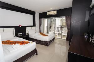 a hotel room with two beds and a balcony at Star House Patong in Patong Beach +45 photos