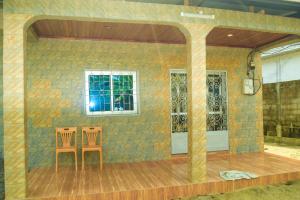 two chairs sitting in front of a room with a wall at Maison Théodosius Plage avec Parking Intérieur in Kribi