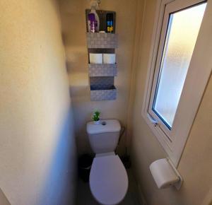 a small bathroom with a toilet and a window at 1A Casa Azul in Pataias