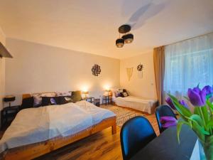 a bedroom with a bed and a table with purple flowers at Rozbrykany Muflon in Witoszów Dolny