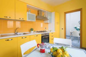 a kitchen with yellow walls and a table with fruit on it at I Tre Delfini apartment in center-Sorrento Coast in Vico Equense