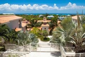 an aerial view of a resort with palm trees and the ocean at Modern villas at Grace Bay, Turks and Caicos Islands in Long Bay Hills