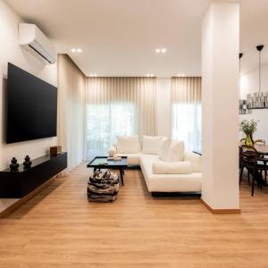 a living room with a white couch and a table at 4bd Apartment With Outdoor Jacuzzi Garden in Athens +11 photos