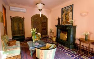 a living room with a fireplace and a fire place at Dar Ayniwen Garden Hotel & Bird Zoo in Marrakesh