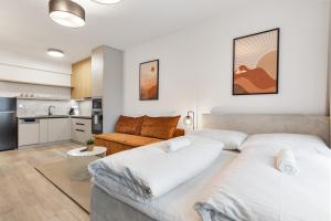 a living room with two beds and a kitchen at LAM Terracotta - AC - Balcony in Bratislava