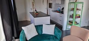 a living room with a green couch and a kitchen at De Strandloper Vakantiehuisje aan het strand - Ferienwohnung am Meer in Baarland +41 photos