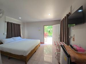 a bedroom with a bed and a flat screen tv at TR Bungalow in Ban Tha Rua
