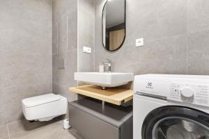 a bathroom with a sink and a washing machine at LAM Terracotta - AC - Balcony in Bratislava
