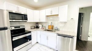 a kitchen with white cabinets and a black stove top oven at Close to the beach #4 Cozy condo in Myrtle Beach