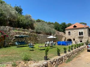 a garden with a stone building and a table and chairs at Aal Aoudeh guesthouse in Dayr al Qamar +27 photos
