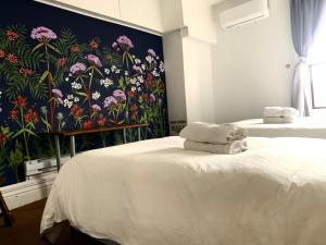 a bedroom with two beds with a floral wall mural at Pensione Popolo in Montreal