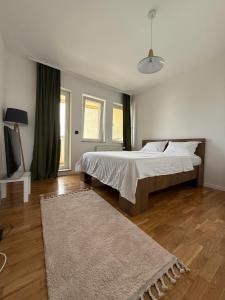a bedroom with a large bed and a rug at Luxury Prishtina Apartment in Pristina