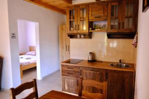 a kitchen with wooden cabinets and a sink and a bed at Sunlight Cottage Maya in Virpazar