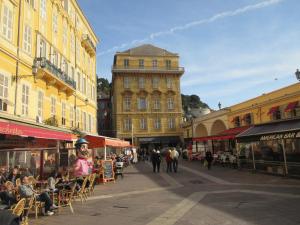 una via cittadina con tavoli e sedie e un edificio di Nice Apartment Old Town a Nizza