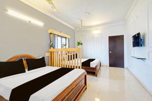 a bedroom with two beds and a crib in it at Hotel O Sahasra Residency Near Nexus Hyderabad in Hyderabad