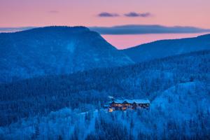 una casa in mezzo a una foresta al tramonto di Auberge de Montagne des Chic-Chocs Mountain Lodge - Sepaq a Sainte-Anne-des-Monts Altre 37 foto