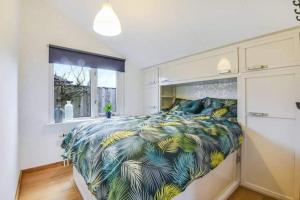 a bedroom with a large bed with a tropical blanket at 2 huizen naast elkaar honden welkom omheinde tuin sauna buitenbad 10 personen in Dirkshorn