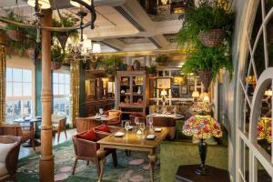 um restaurante com mesas, cadeiras e plantas em Mandarin Oriental, Hong Kong em Hong Kong