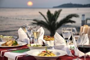 a table with plates of food and glasses of wine at Ephesia Holiday Beach Club in Kuşadası