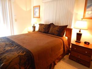 Un dormitorio con una cama grande y dos lámparas. en Timber Run, en Winter Park