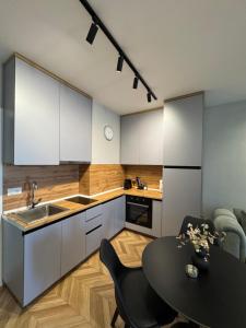 a kitchen with a table and a kitchen with white cabinets at The Best Shkoder in Shkodër +6 photos