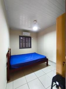 a bedroom with a blue bed in a room at Oasis Sul Tramandaí Casa Vermelha in Tramandaí