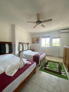 a bedroom with two beds and a ceiling fan at VILLA COSTERA HOTEL BOUTIQUE in Acapulco +17 photos