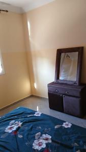 a bedroom with a bed and a dresser with a mirror at Saidia appartments in Saïdia +3 photos