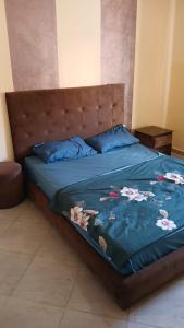 a bed with a blue comforter with flowers on it at Saidia appartments in Saïdia