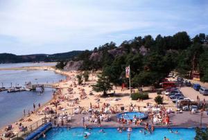 a group of people on a beach with a pool at Romslig familiehus på Sørlandskysten in Kristiansand
