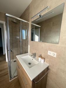 ein Badezimmer mit Waschbecken und Dusche mit Spiegel in der Unterkunft O Refuxio da Ría in Pontevedra + 33 Fotos