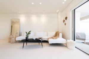 a living room with a white couch and a table at 2bd Boho Sea View Apartment By The Olon in Vari