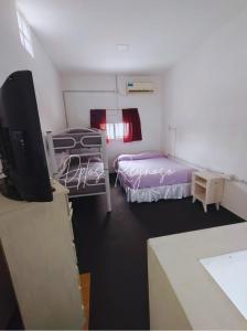 a room with two beds and a flat screen tv at Dptos Reynoso in Villa Mercedes