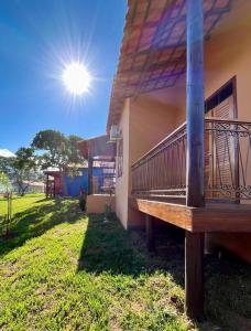a porch of a house with the sun in the sky at Chalés da Marisa - Serra da Canastra in São João Batista do Glória