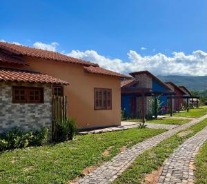 a house with a cobblestone road next to a house at Chalés da Marisa - Serra da Canastra in São João Batista do Glória