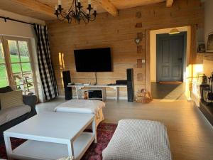 a living room with a couch and a tv at Miętowa Dolina in Baligród
