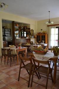 a dining room with tables and chairs and a kitchen at Ξενώνας Αλώνι-Guesthouse Aloni in Theodoriana