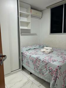 een kleine slaapkamer met een bed met bloemen erop bij Villa Natal, cond villa das palmeiras in Jaboatao dos Guararapes