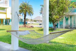 a hammock in a yard next to a house at Pet-Friendly, Arcade Games, Beach, Ocean View in Bolivar Peninsula