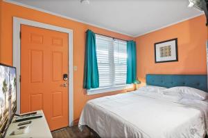 a bedroom with a bed and a window and a door at Step Back in Time- Golden Era Retro Motel in Saint Augustine