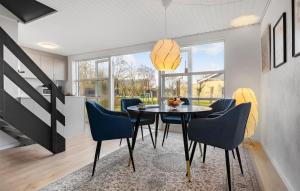 jadalnia ze stołem i niebieskimi krzesłami w obiekcie 3 Bedroom Cozy Home In Farsø w mieście Farsø