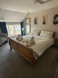 a bedroom with a large bed with two pillows on it at April Cottage in Bacton