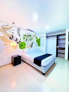 une chambre avec un lit avec un tableau sur le mur dans l'établissement Playa Norte Hotel, à Carthagène des Indes