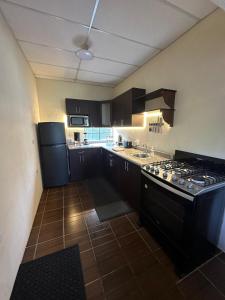 a kitchen with black cabinets and a stove top oven at Casa de Campo in Santa Cruz Verapaz