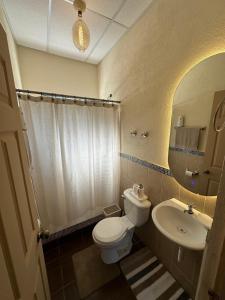 a bathroom with a white toilet and a sink at Casa de Campo in Santa Cruz Verapaz