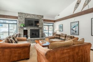 Una sala de estar con sofás y chimenea. en Silverbear #41 - 2 Bedrm + Loft / 3 Bathrm 1/2 block to Canyon Lodge! Slps 8, en Mammoth Lakes