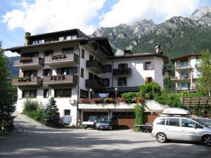 ein großes Gebäude mit davor geparkt in der Unterkunft Albergo Miravalle in Auronzo di Cadore